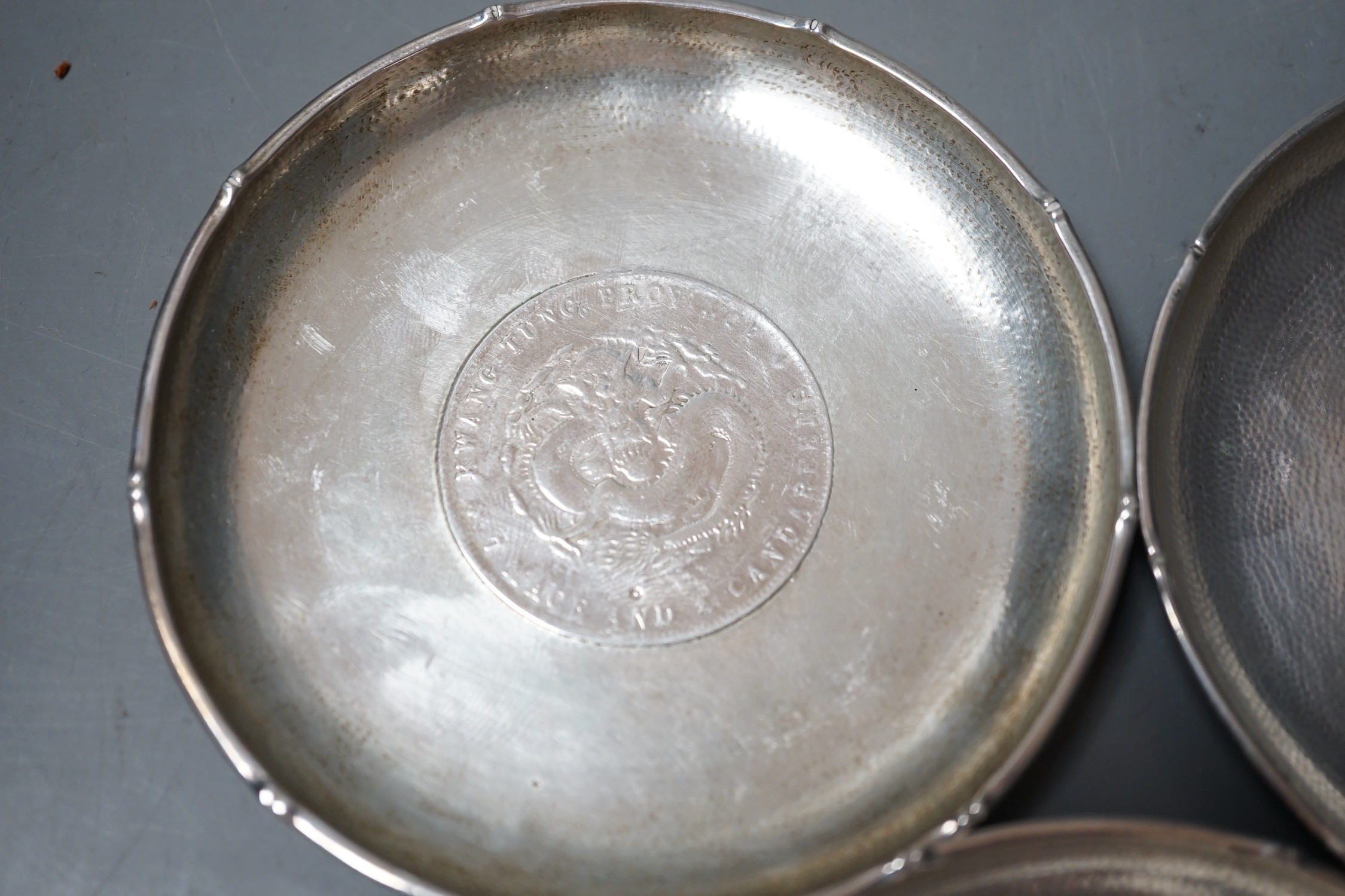 Three Chinese white metal dishes, each inset with coin, maker HC, 94mm, 196 grams gross.